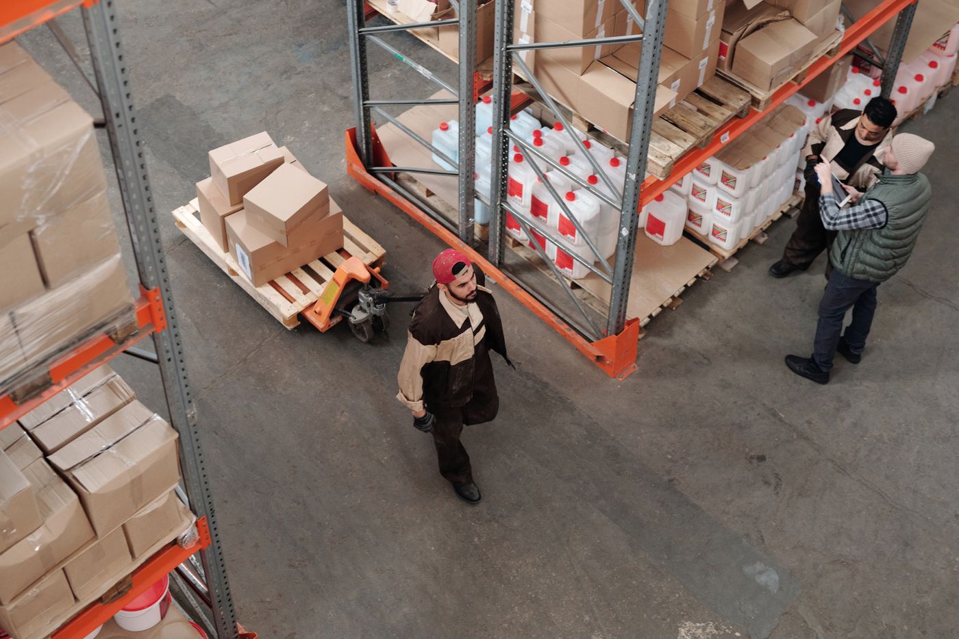 Warehouse team members reviewing inventory and operations among stocked shelving